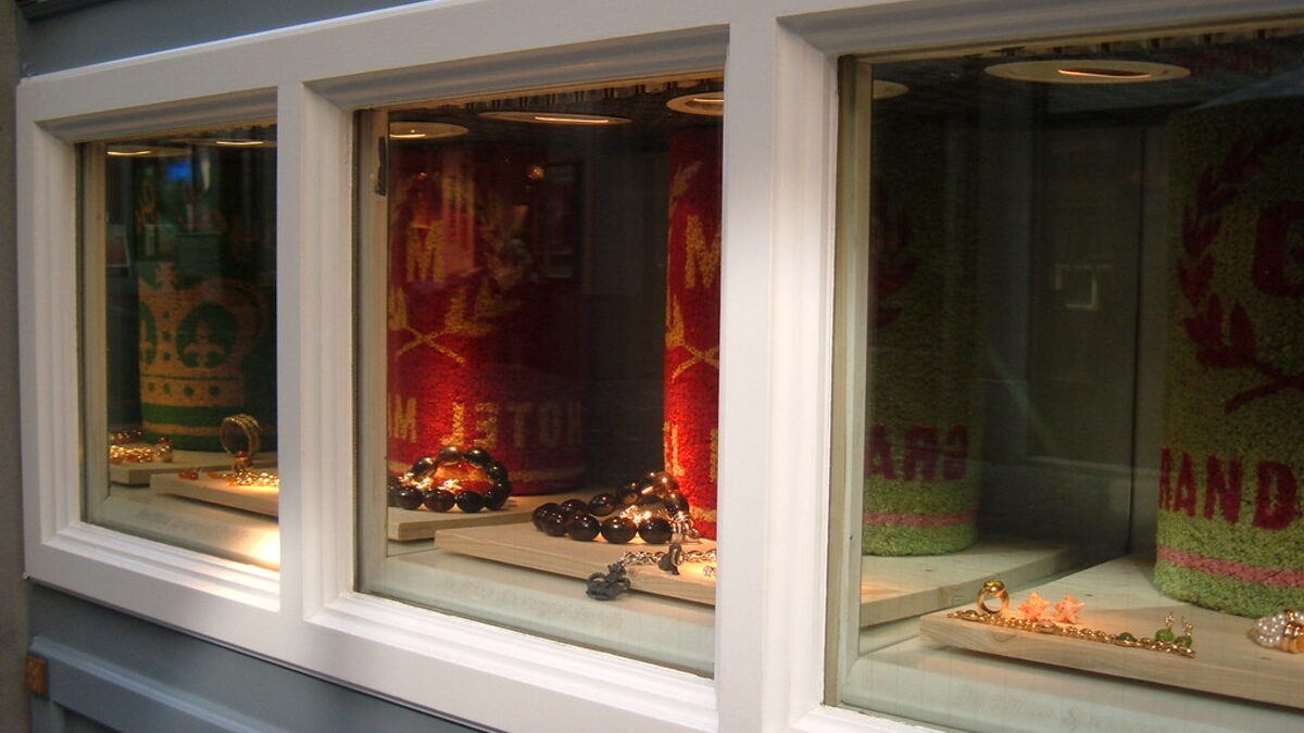 A small retail shopfront in a white painted frame, its display window clean and clear